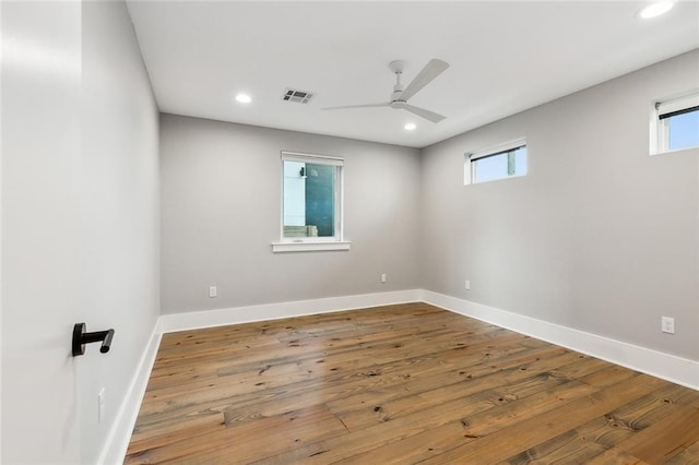 unfurnished room featuring a healthy amount of sunlight, hardwood / wood-style floors, and ceiling fan