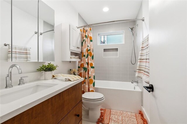 full bathroom with shower / bathtub combination with curtain, vanity, and toilet