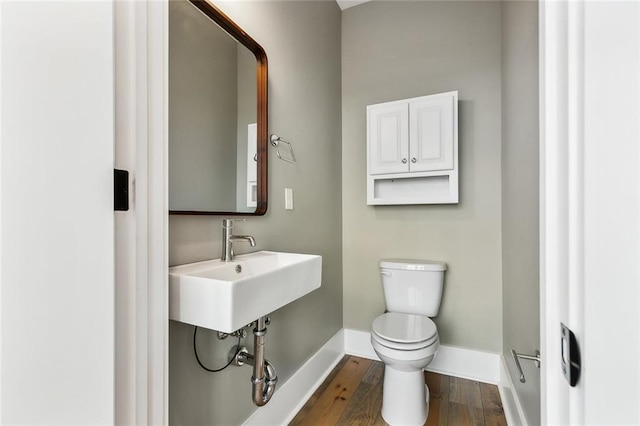 bathroom featuring wood-type flooring, sink, and toilet