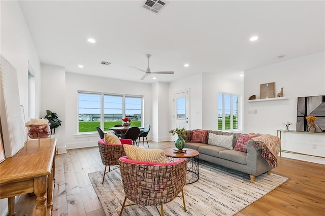 living room with light hardwood / wood-style floors and ceiling fan