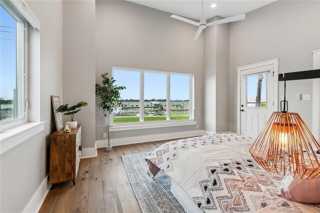 bedroom featuring light hardwood / wood-style flooring and a towering ceiling