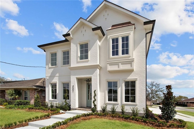 greek revival house with a front lawn and brick siding