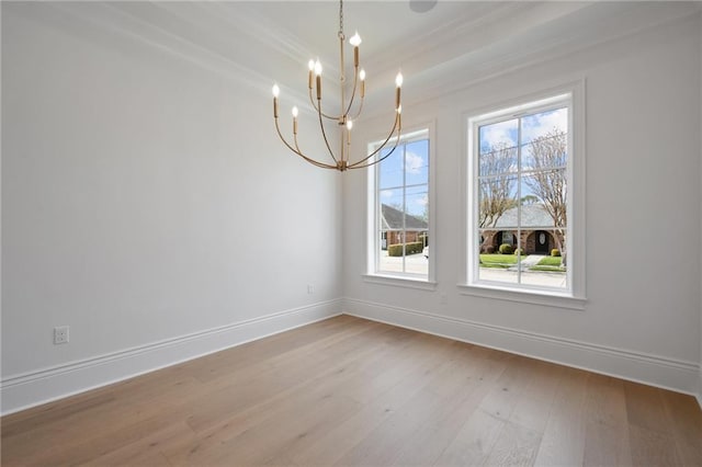 unfurnished dining area featuring ornamental molding, a chandelier, and light wood-type flooring