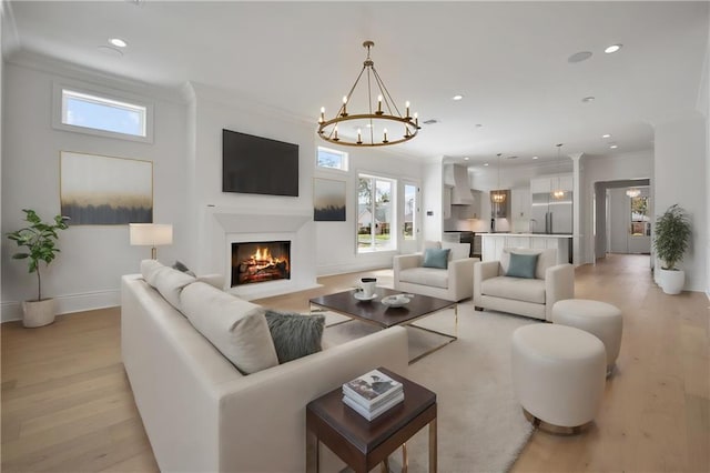 living room featuring crown molding, light hardwood / wood-style flooring, and a chandelier