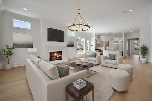 living room with a fireplace with flush hearth, recessed lighting, crown molding, baseboards, and light wood-style flooring