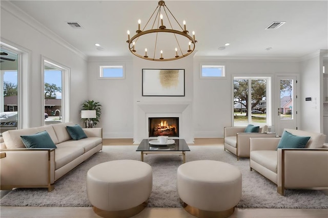 living room featuring crown molding, light hardwood / wood-style floors, and an inviting chandelier