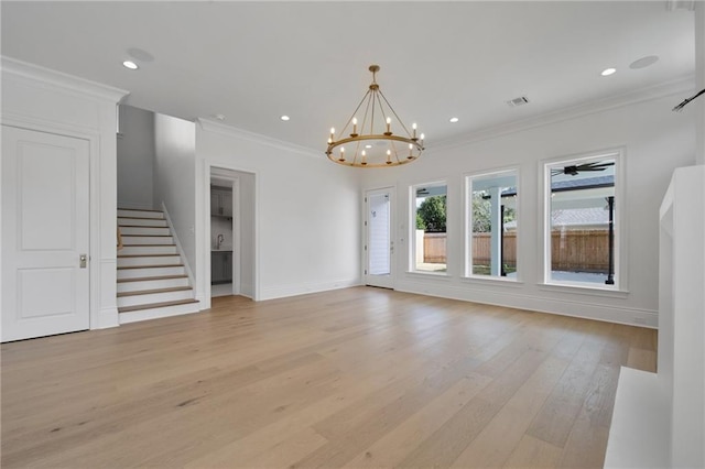 unfurnished living room featuring light hardwood / wood-style floors, ornamental molding, and ceiling fan with notable chandelier