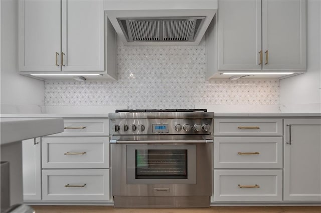 kitchen featuring backsplash, ventilation hood, and high end stove