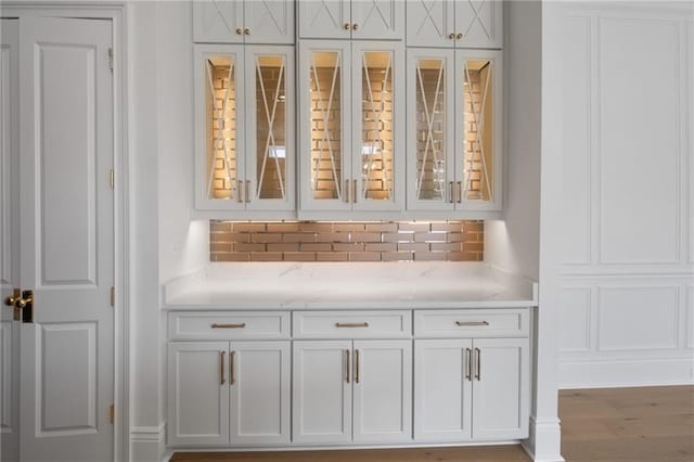 room details with decorative backsplash and wood-type flooring