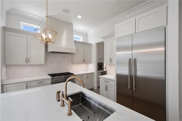 kitchen with decorative backsplash, high quality appliances, hanging light fixtures, custom range hood, and ornamental molding