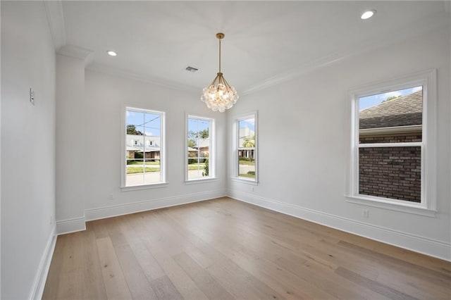 unfurnished dining area with light hardwood / wood-style floors, ornamental molding, and a chandelier