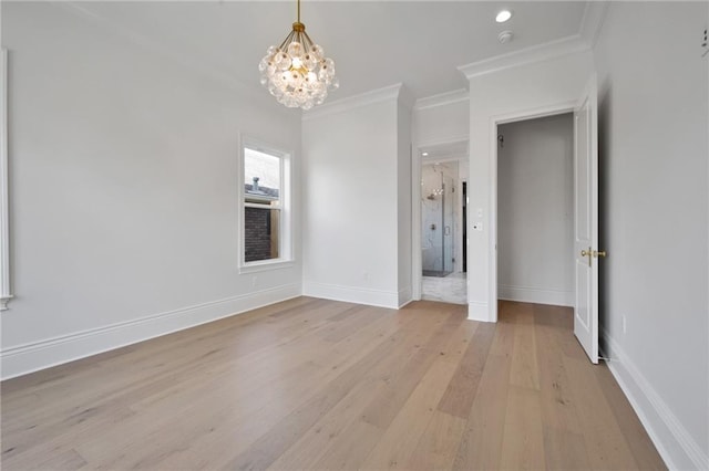 unfurnished room featuring an inviting chandelier, crown molding, and light hardwood / wood-style floors