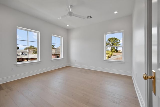 empty room with ceiling fan, plenty of natural light, and light wood-type flooring