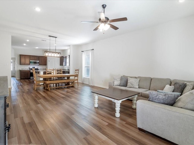 living room with wood-type flooring and ceiling fan