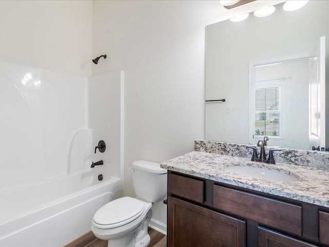 full bathroom with hardwood / wood-style floors,  shower combination, vanity, and toilet