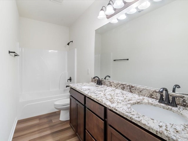 full bathroom featuring vanity, hardwood / wood-style flooring, bathtub / shower combination, and toilet