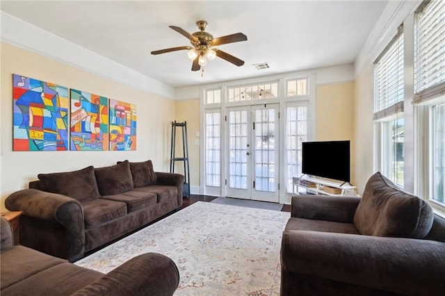 living room featuring wood-type flooring, ceiling fan, and french doors