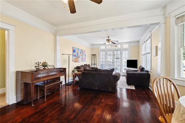 living room featuring ceiling fan, plenty of natural light, and dark wood-type flooring