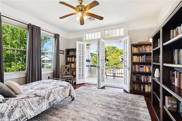 bedroom with french doors, ceiling fan, multiple windows, and dark wood-type flooring