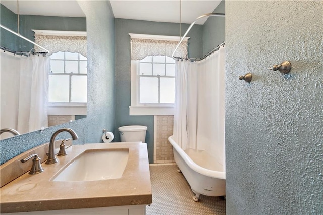 full bathroom featuring tile patterned flooring, vanity, toilet, and plenty of natural light