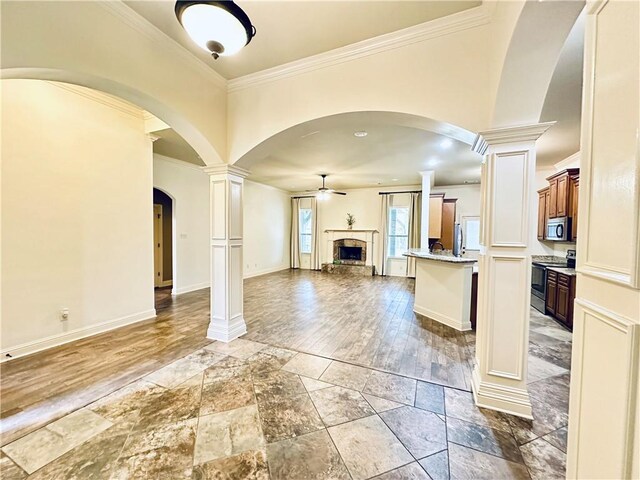 kitchen with light stone countertops, appliances with stainless steel finishes, crown molding, and sink