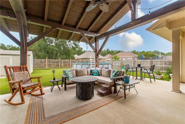 view of patio / terrace featuring a fenced in pool, ceiling fan, and an outdoor fire pit