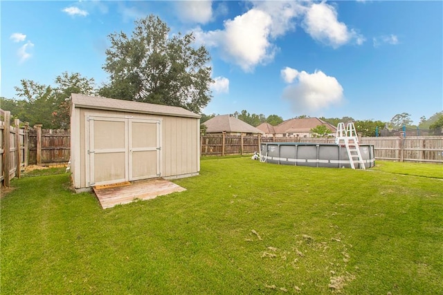 view of yard featuring a fenced in pool and a shed