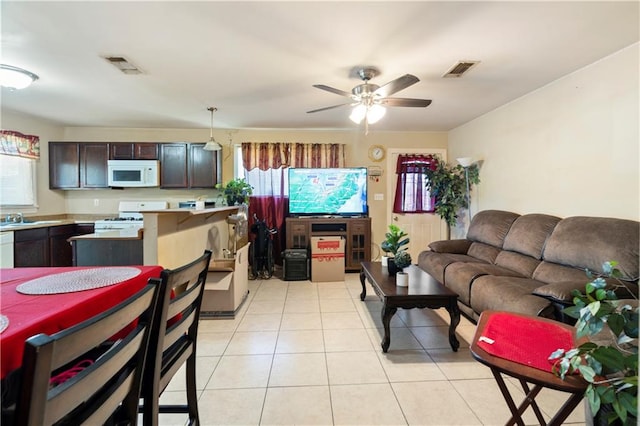 tiled living room featuring ceiling fan and sink