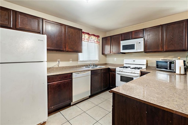 kitchen with dark brown cabinetry, white appliances, sink, and light tile patterned floors