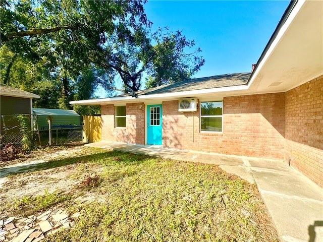 exterior space with a yard and an AC wall unit