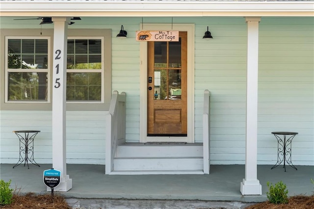 doorway to property with ceiling fan and a porch