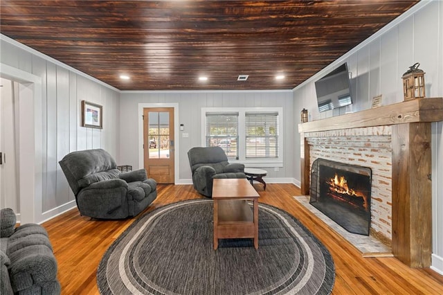 living room with wood ceiling, light hardwood / wood-style floors, and ornamental molding