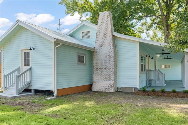 rear view of property with a lawn and ceiling fan