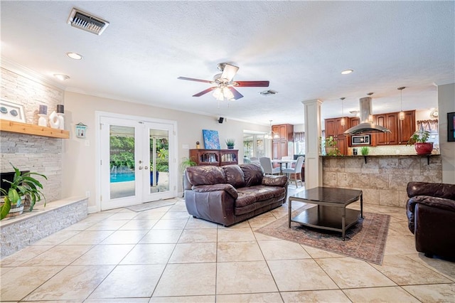 living room featuring a fireplace, light tile patterned floors, ceiling fan, french doors, and ornamental molding