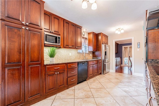 kitchen with sink, backsplash, appliances with stainless steel finishes, light tile patterned floors, and light stone countertops