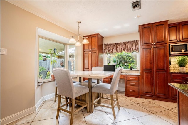 dining room featuring an inviting chandelier, crown molding, and light tile patterned floors