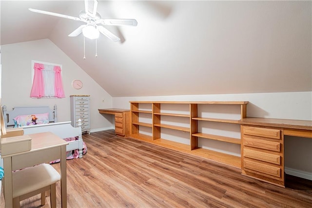 bonus room featuring built in desk, wood-type flooring, lofted ceiling, and ceiling fan