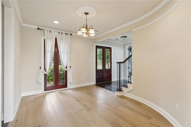 entrance foyer featuring an inviting chandelier, french doors, and hardwood / wood-style floors