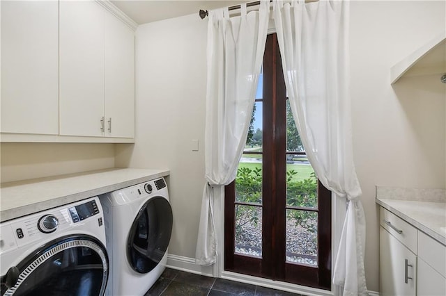 laundry area with cabinets, washer and dryer, and dark tile patterned flooring