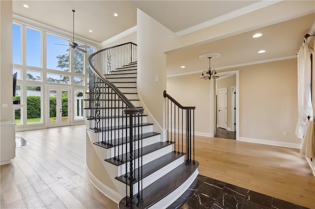 stairs with crown molding, hardwood / wood-style flooring, and a wealth of natural light