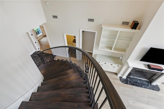 stairs with a towering ceiling and hardwood / wood-style flooring