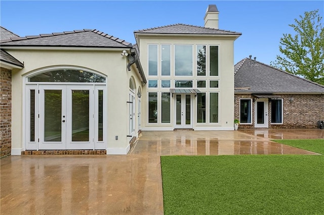 back of house featuring french doors, a patio area, and a yard