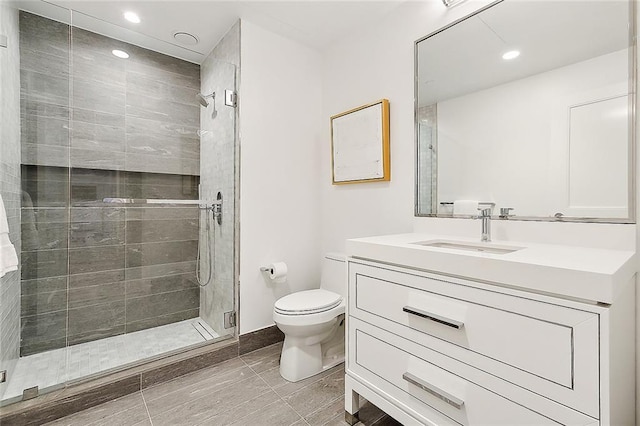 bathroom with an enclosed shower, vanity, and toilet