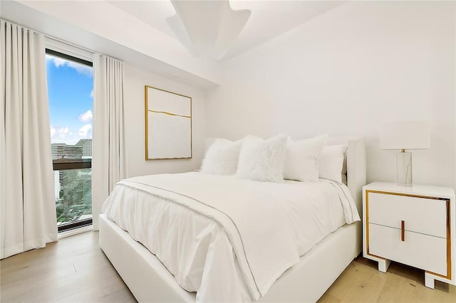 bedroom with multiple windows and light hardwood / wood-style flooring