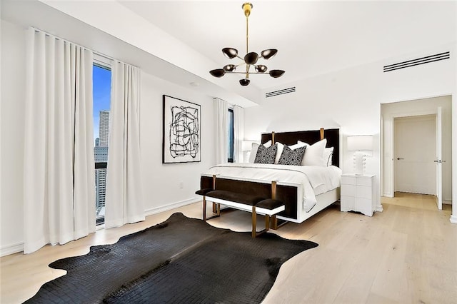 bedroom featuring an inviting chandelier and light wood-type flooring