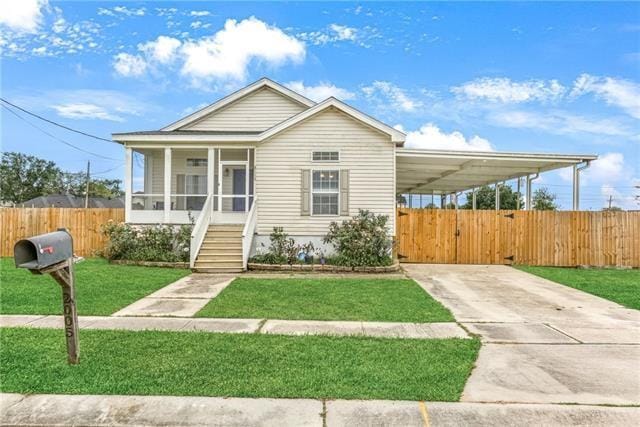 view of front of home with a carport and a front lawn