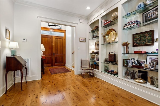 foyer featuring crown molding and hardwood / wood-style floors