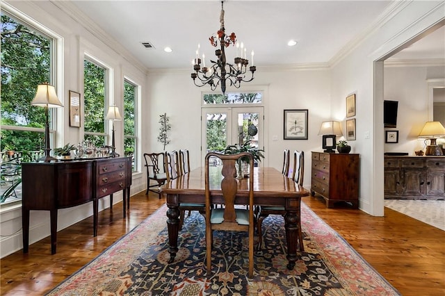 dining room featuring french doors, ornamental molding, a chandelier, and dark hardwood / wood-style flooring