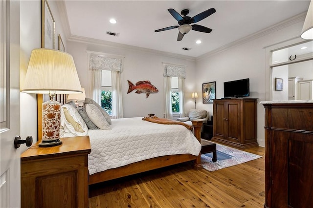 bedroom with wood-type flooring, ornamental molding, and ceiling fan