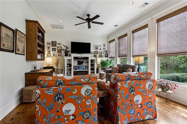 living room featuring ceiling fan, plenty of natural light, hardwood / wood-style floors, and crown molding